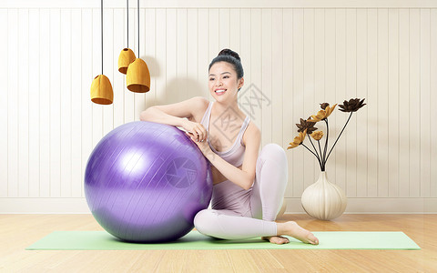 瑜伽垫瑜伽球室内做瑜伽的人设计图片