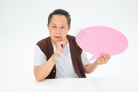 手拿粉色对话气泡框的老年人背景图片