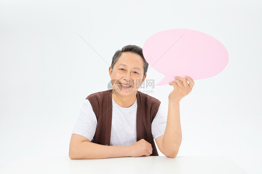 手拿粉色对话气泡框的老年人图片