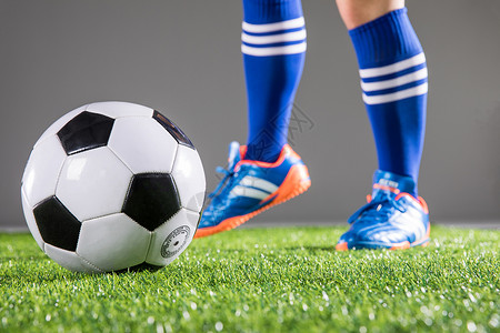 足球运动员踢球动作草地背景图片