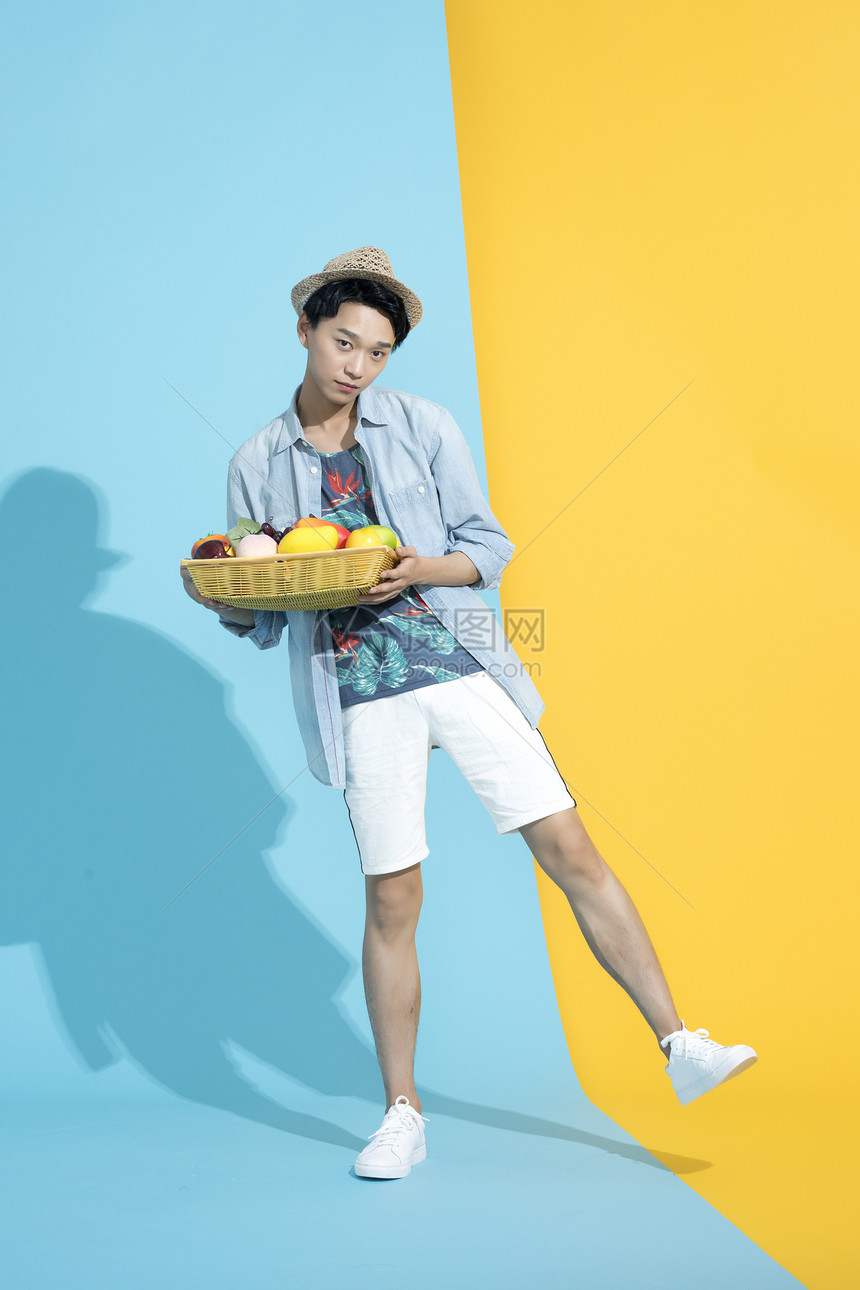 拿着水果篮子的青年男性图片