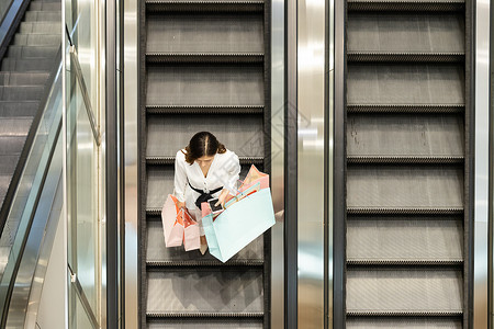 青年女性商场购物坐扶梯高清图片
