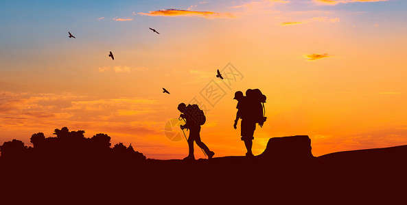 背包背景夕阳下登山人物剪影设计图片