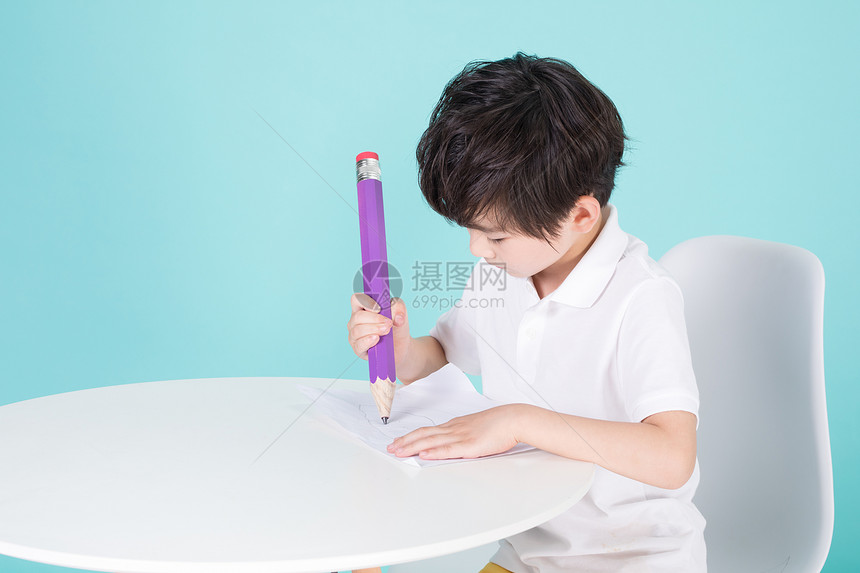 儿童教育小男孩手持超大铅笔学习图片
