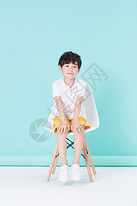 坐在凳子上的小男孩儿童背景图片