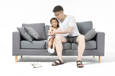 爸爸和女儿在沙发上看电视背景图片