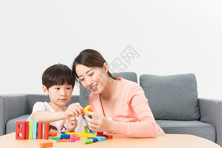 母子玩具母亲陪伴儿子玩积木背景