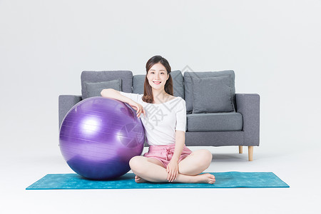 居家女性瑜伽球健身背景图片