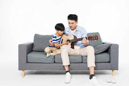 父亲节弹吉他沙发上父子弹吉它背景