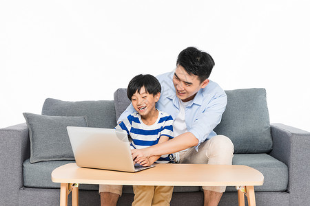 上网男孩沙发上父亲指导孩子用电脑背景