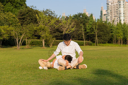 身边的公园里孩子在父亲身边休息背景