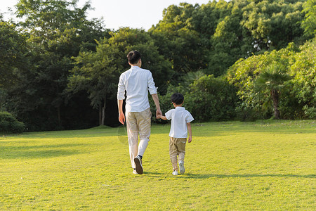 男孩走路漫画父亲节公园里牵手散步父子背影背景