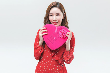 漂亮的红色爱心时尚青年女性手持心形礼盒背景