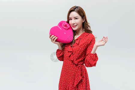 漂亮的红色爱心时尚青年女性手持心形礼盒背景
