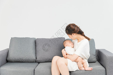 家居宝宝母婴沙发上妈妈抱着宝宝睡觉背景