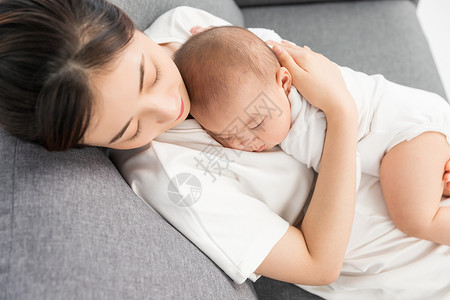 抱着孩子母亲母婴沙发上妈妈抱着宝宝睡觉背景