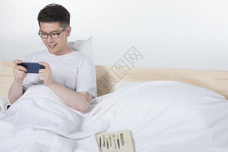 低头看手机爸爸在床上看手机背景