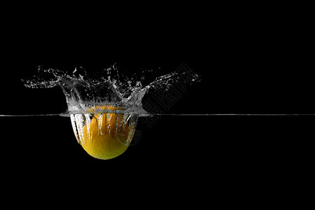 水果在水中溅起水花一颗掉落水中溅起水花的柠檬背景