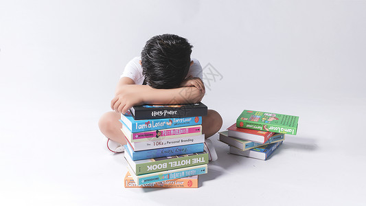 小孩子在书堆中疲劳困扰高清图片