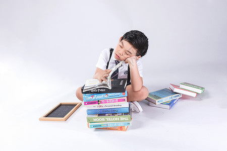 小孩子在书堆中疲劳困扰图片
