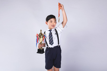 穿背带裤的男孩子男孩子获得奖杯奖牌背景
