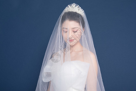 头戴头纱穿婚纱的新娘背景图片