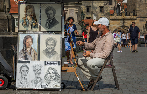 布拉格查理大桥上画画的街头艺人背景图片