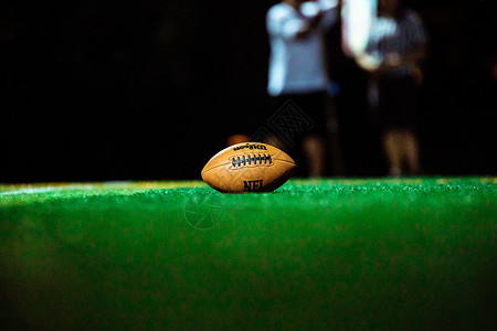 草地上的橄榄球背景图片