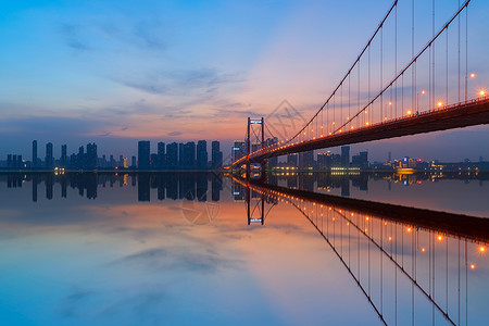 江上夜景夕阳落日下的武汉长江上的桥梁背景