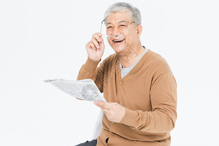 老年人戴眼镜看报纸背景图片