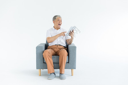 老人坐沙发老年人和平板电脑背景