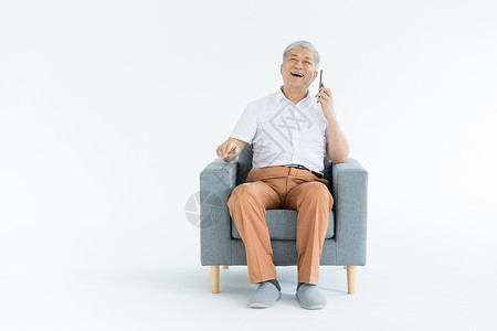 老人坐沙发老年人手机打电话背景