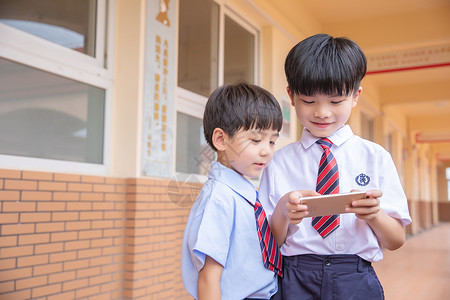 两个小学生小学生玩手机游戏背景