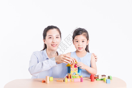 母亲陪女儿玩积木背景图片