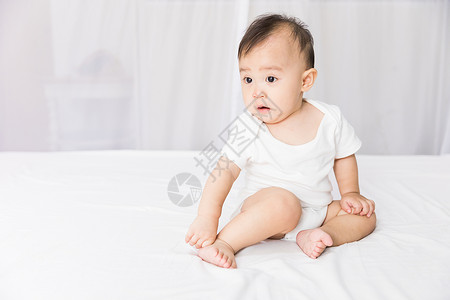 婴儿坐在床上图片