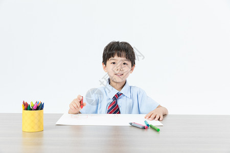 蜡笔男孩书桌上画画的儿童背景