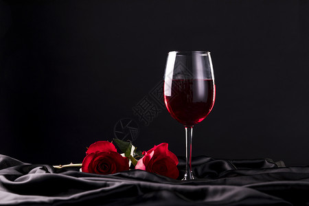 平铺的黑色丝绸红酒高脚杯背景