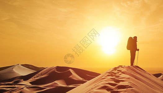 走沙漠的人拥抱夕阳高清图片
