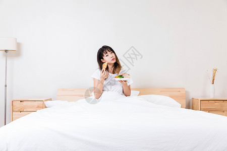 在床上吃早餐的女孩背景图片