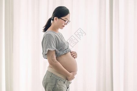 宝妈兼职站在窗前的孕妇背景