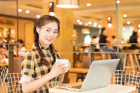 咖啡店青春女孩用电脑看电影背景