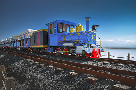 阳光跑道茶卡盐湖上的蓝色火车背景