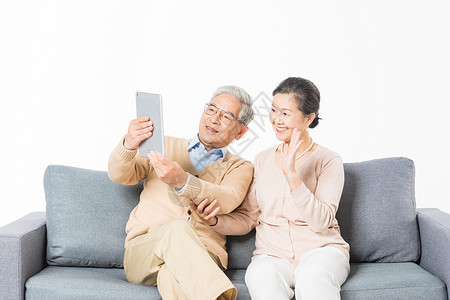 家庭人物科技老年夫妻用平板电脑视频通话背景