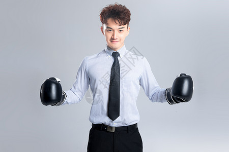 戴拳击手套的商务男女年轻商务男子戴着拳击手套背景