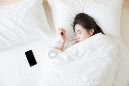 年轻女性睡觉与手机图片
