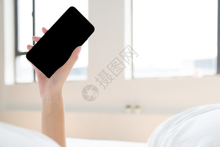 年轻女性睡觉看手机特写图片