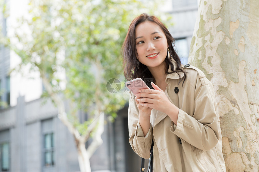 年轻美女拿手机微笑图片