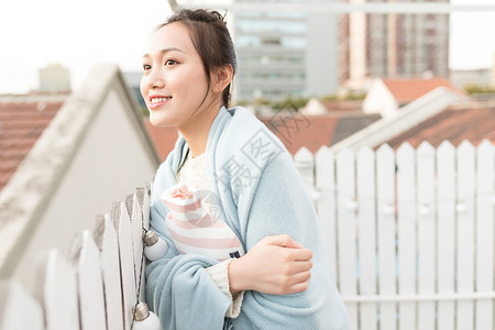 女生抱暖手袋特写图片