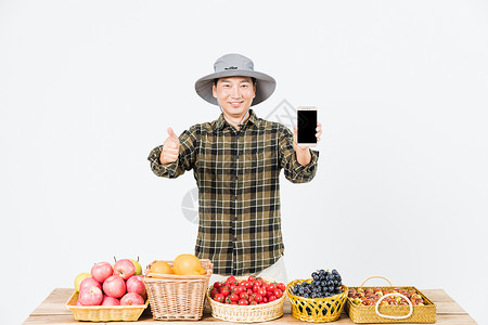 手拿葡萄男性果农水果出售手机交易背景