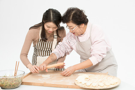 女儿和妈妈一起包饺子背景图片